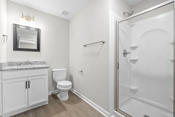 a bathroom with a granite countertop toilet sink and mirror