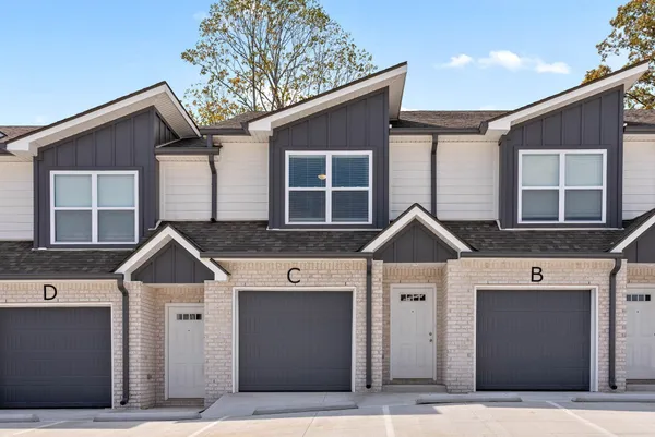 a view of a hallway with wooden floor and a bathroom