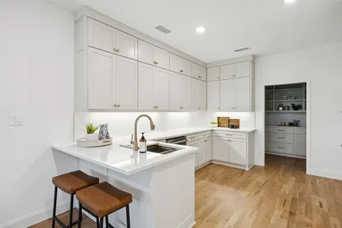 a kitchen with a sink cabinets and wooden floor