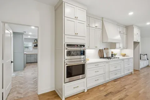 a kitchen with stainless steel appliances white cabinets and a refrigerator