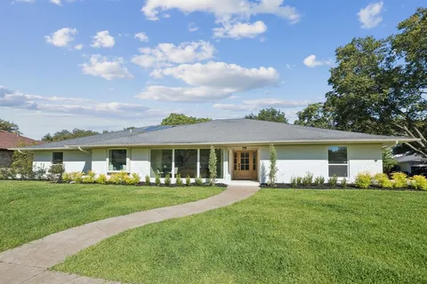 a front view of house with a garden and patio