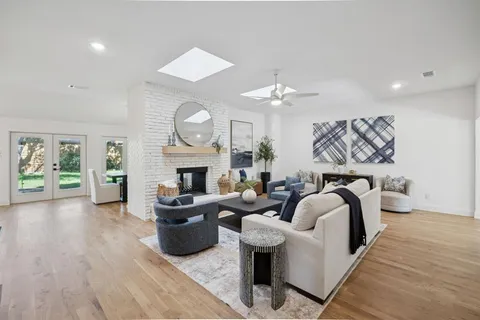 a living room with furniture a fireplace and a chandelier