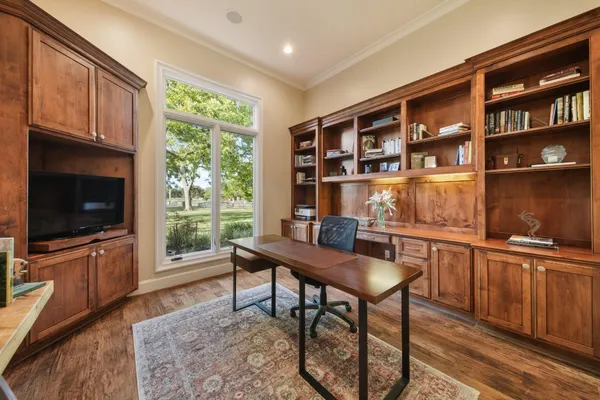 a living room with furniture a flat screen tv and a floor to ceiling window