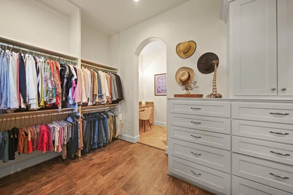 a view of walk in closet with clothes and shoes