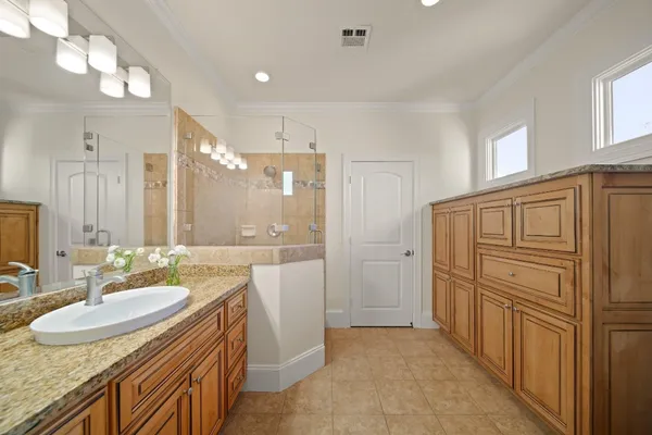a bathroom with sink shower and mirror