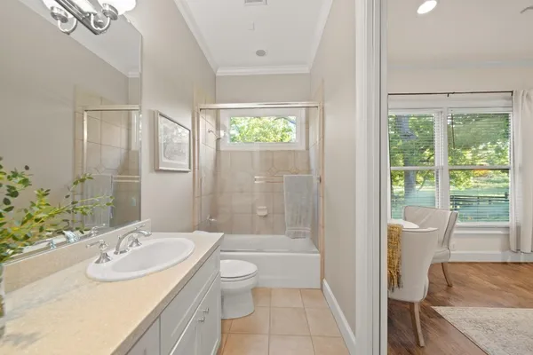 a bathroom with a granite countertop sink a toilet a mirror and shower