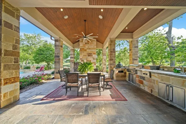 a view of a patio with dining table chairs and a potted plant