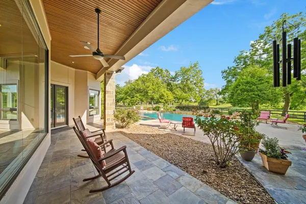 a view of a patio with table and chairs potted plants and large tree