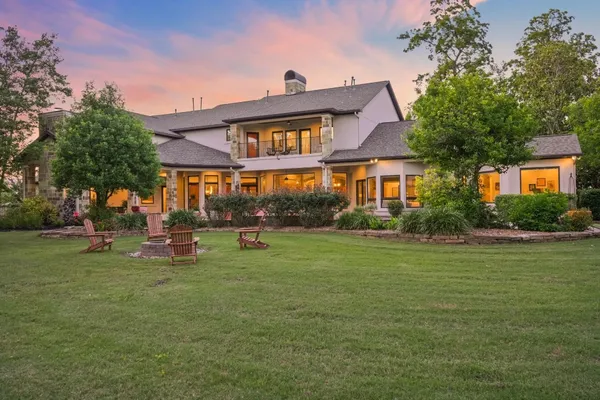 a front view of a house with a garden and trees