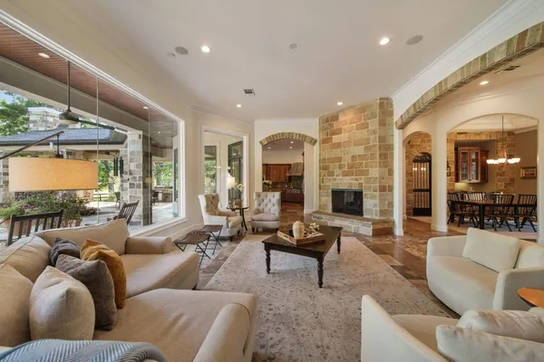 a living room with furniture fireplace and large windows