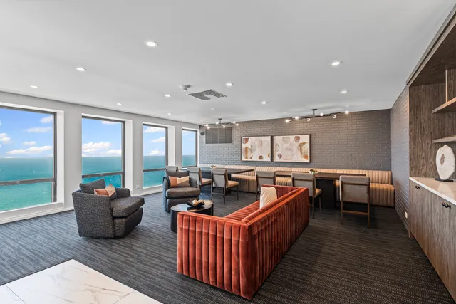 a living room with furniture kitchen view wooden floor and windows