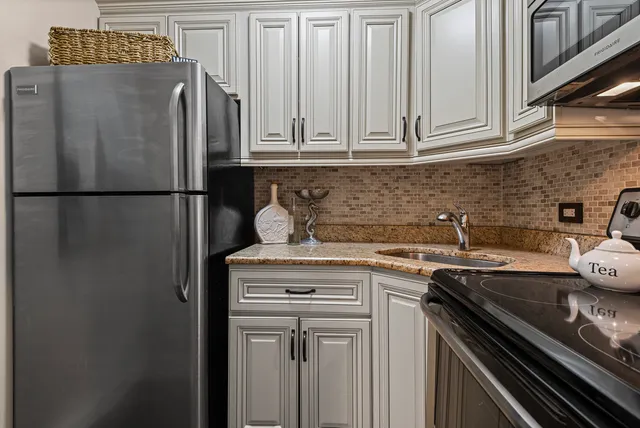 a kitchen with stainless steel appliances granite countertop a refrigerator a sink and dishwasher