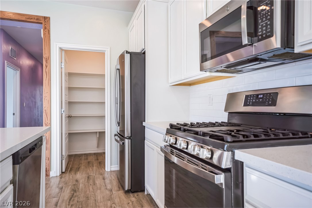 7348 North Decatur Boulevard, Unit 1 North Las Vegas, NV 89084 - Photo 3 of 17 Culinary creations come to life with stainless steel appliances and abundant pantry storage in this pristine kitchen.