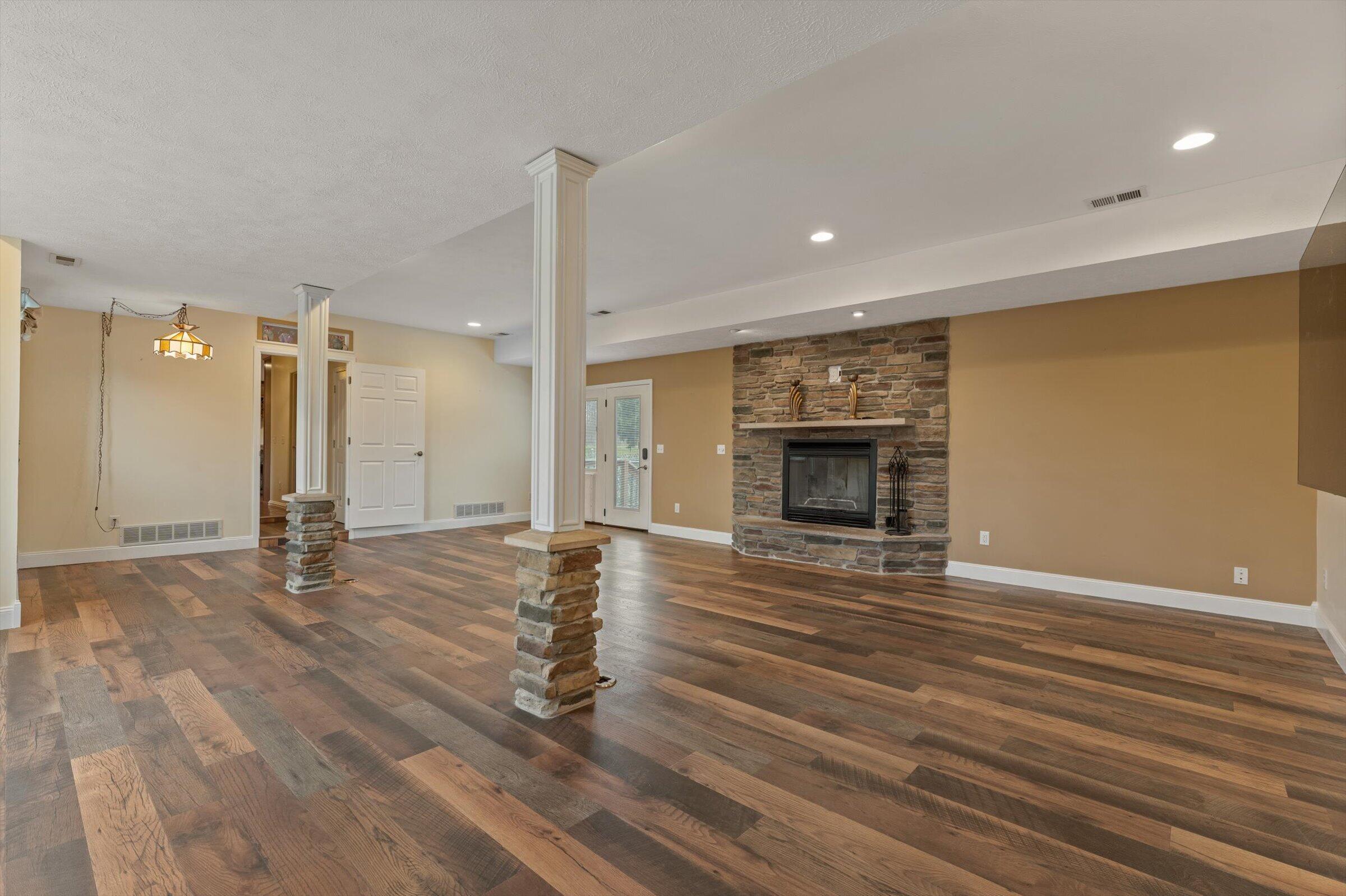 7692 North Emery Road Rolling Prairie, IN 46371 - Photo 9 of 69 a view of empty room with wooden floor and fireplace