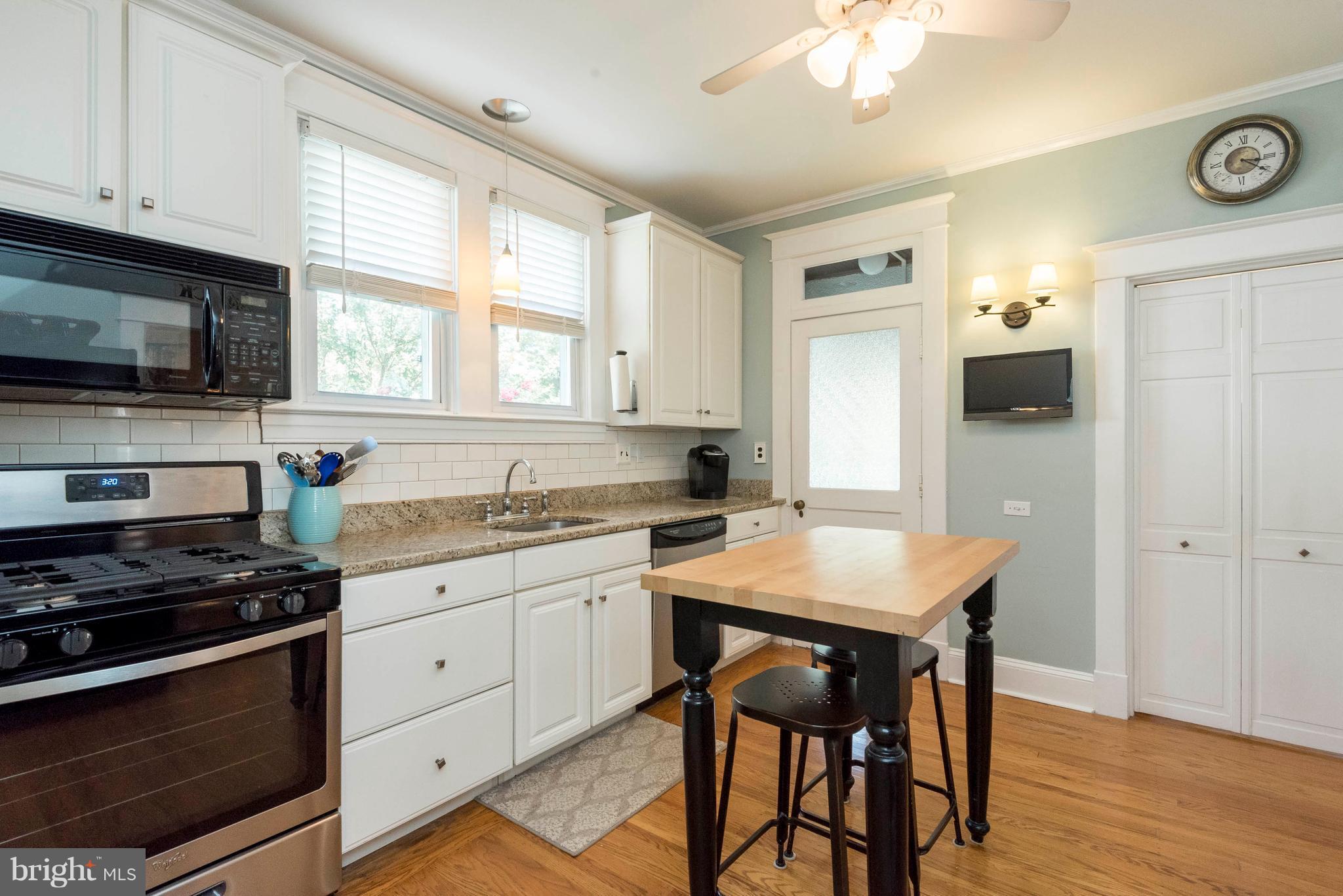 3 Mallow Hill Road Baltimore, MD 21229 - Photo 7 of 30 a kitchen with granite countertop a stove a sink cabinets and wooden floor