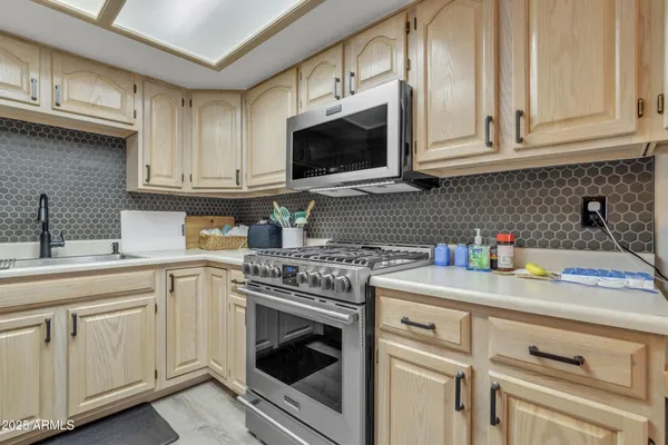 a kitchen with stainless steel appliances granite countertop white cabinets a sink and dishwasher
