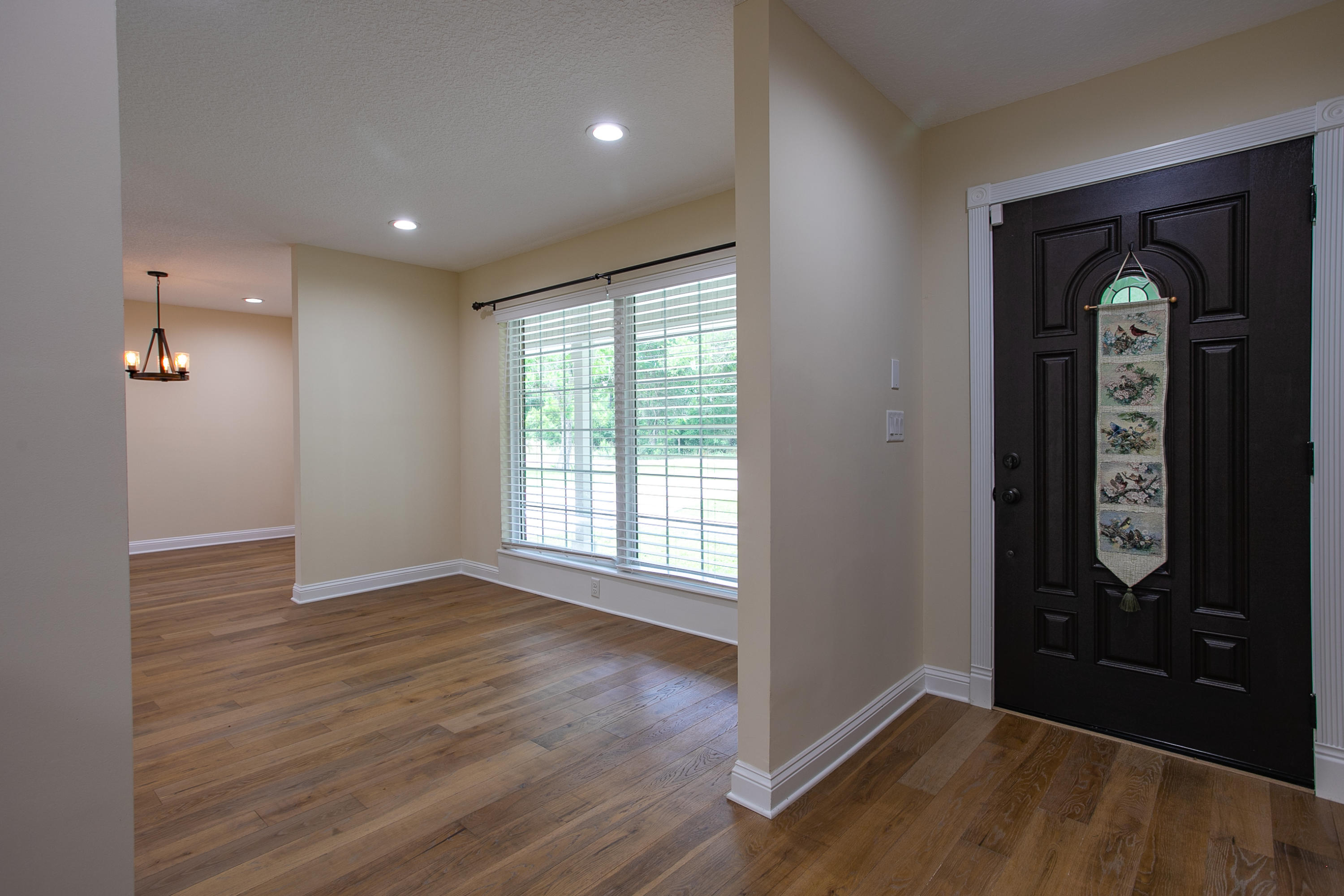 96165 Pirates Bluff Road Yulee, FL 32097 - Photo 4 of 28 an empty room with wooden floor mirror and windows