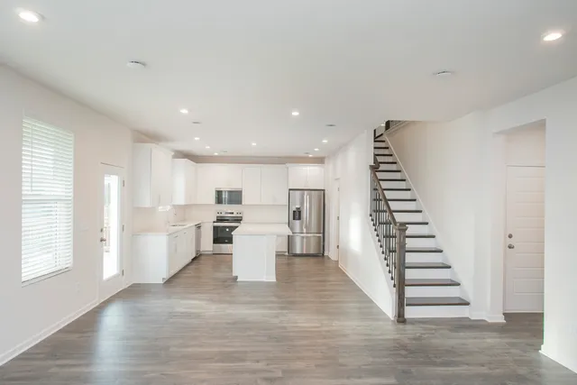 a kitchen with a refrigerator a sink and white cabinets