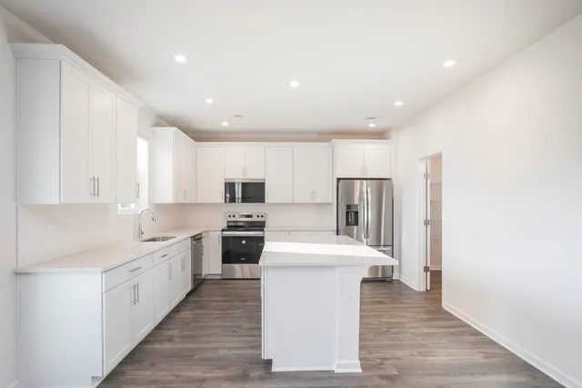 a kitchen with white cabinets and stainless steel appliances