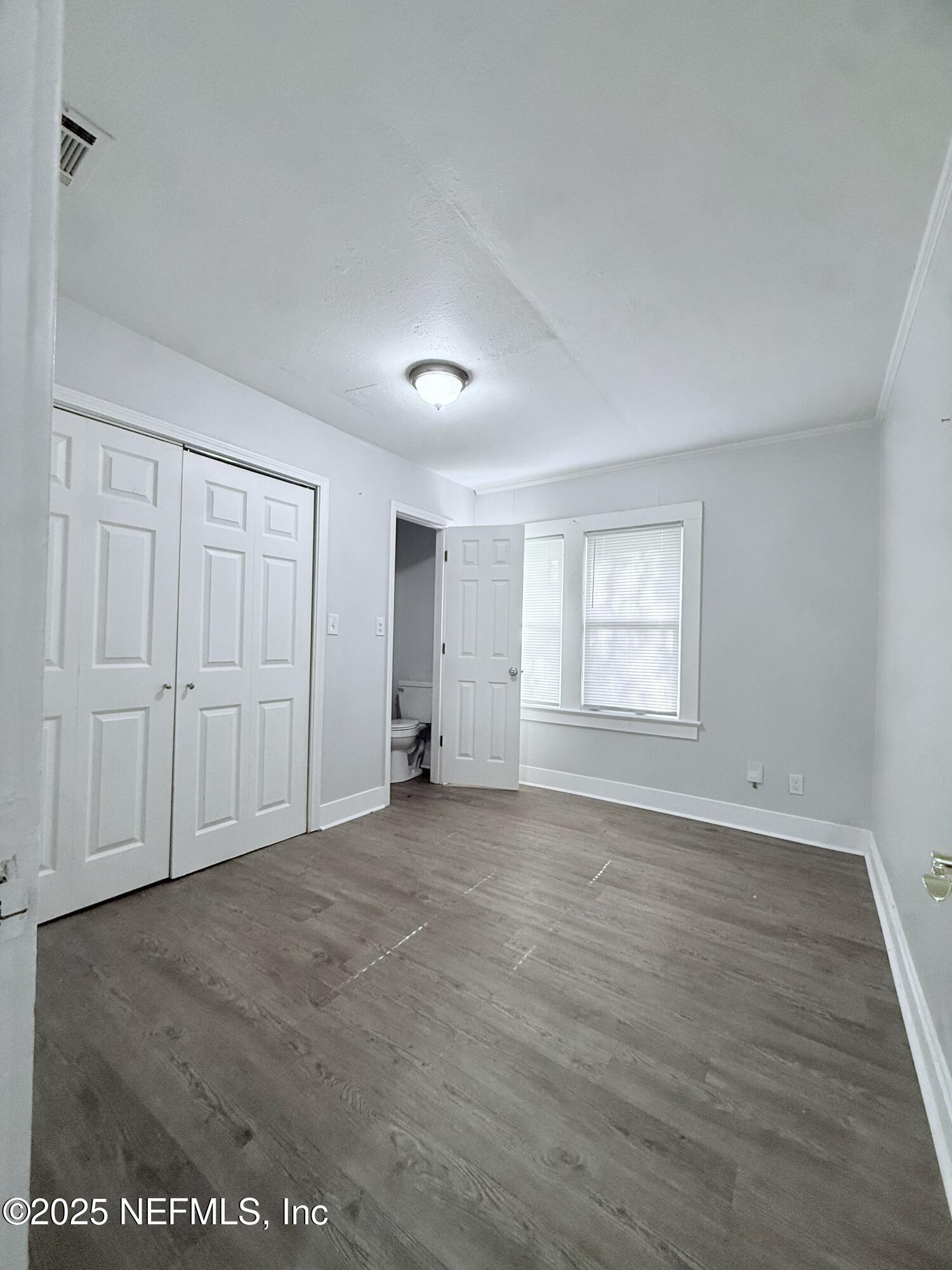 10728 Old Kings Road Jacksonville, FL 32219 - Photo 16 of 27 an empty room with wooden floor and windows