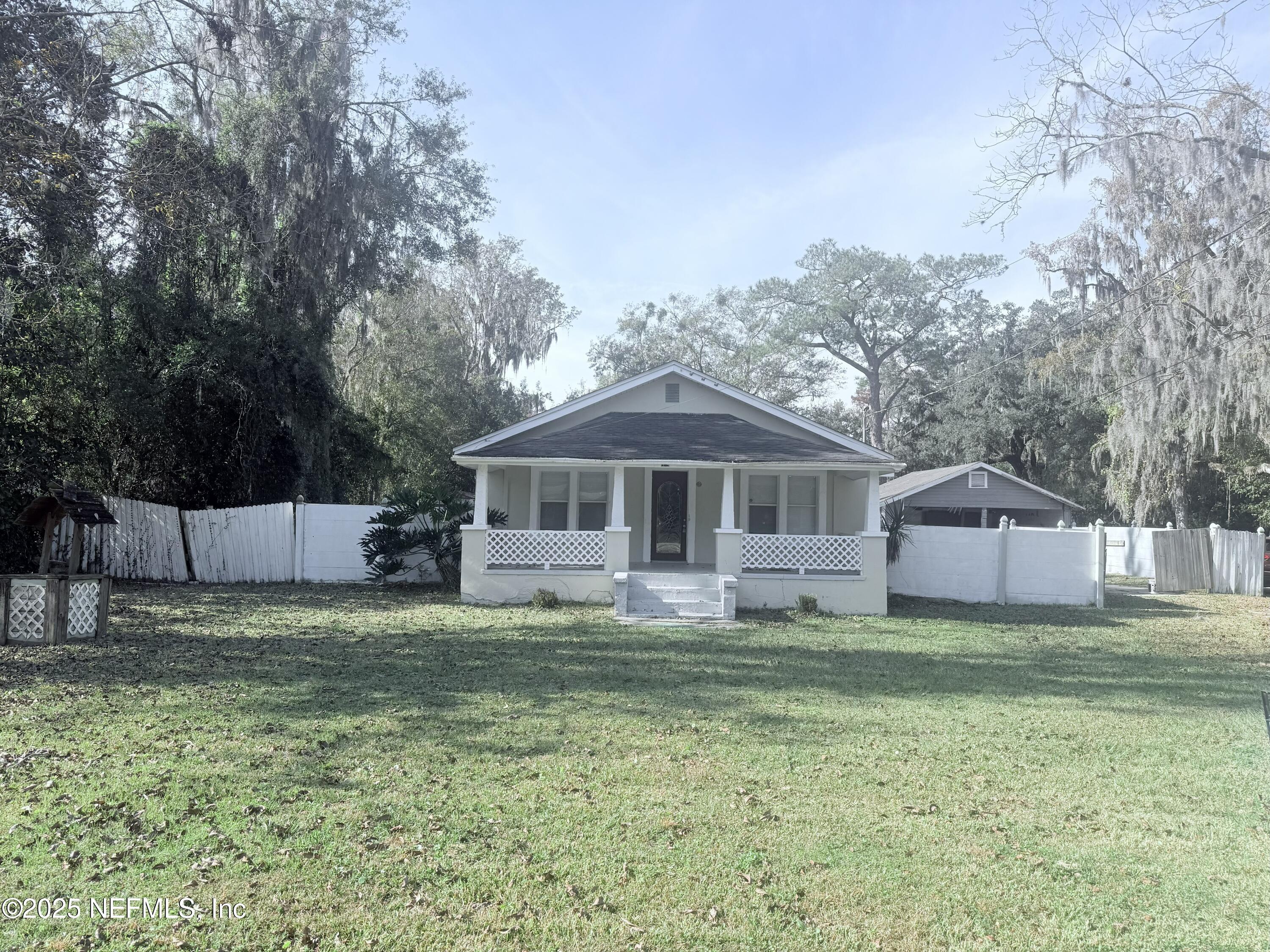 10728 Old Kings Road Jacksonville, FL 32219 - Photo 3 of 27 a white house with a small yard and large trees