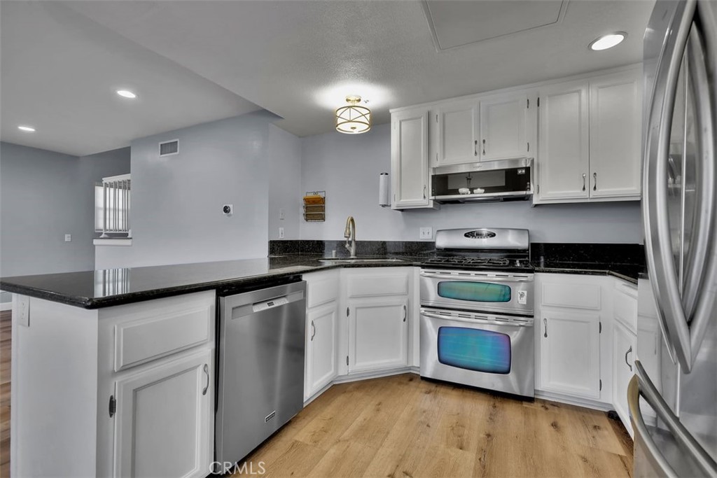 755 North East Street Anaheim, CA 92805 - Photo 19 of 31 a kitchen with granite countertop a sink cabinets and stainless steel appliances