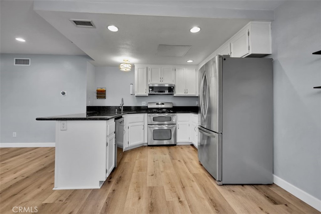 755 North East Street Anaheim, CA 92805 - Photo 21 of 31 a kitchen with granite countertop a refrigerator oven a sink and white cabinets
