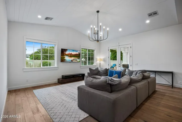 a living room with furniture kitchen and a chandelier