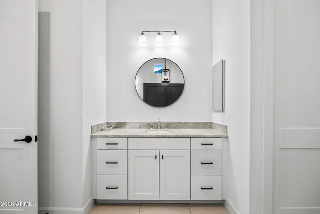 a en suite bathroom with a granite countertop sink and a mirror