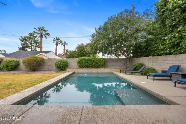 a view of a house with pool and chairs