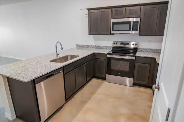 a kitchen with stainless steel appliances granite countertop a sink stove and microwave