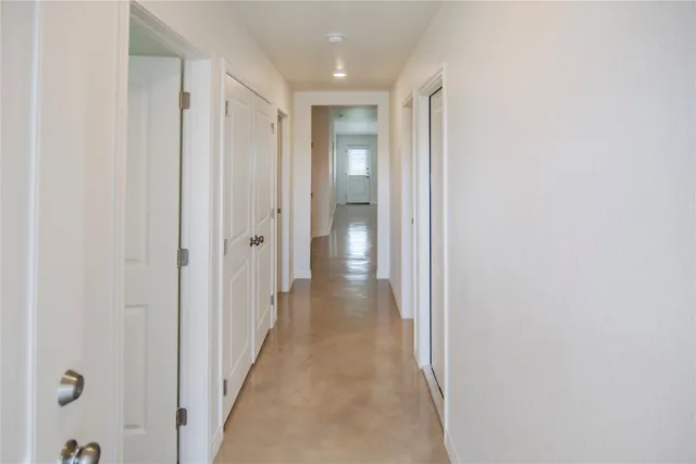 a view of a hallway with wooden floor and closet
