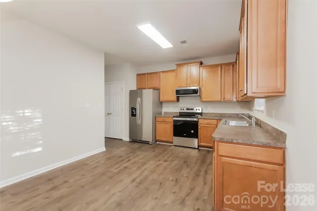 a kitchen with granite countertop a refrigerator sink and cabinets