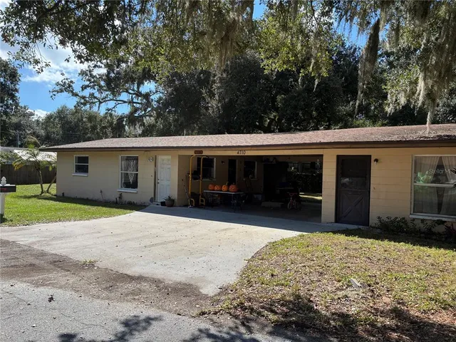a front view of house with yard and trees in the background