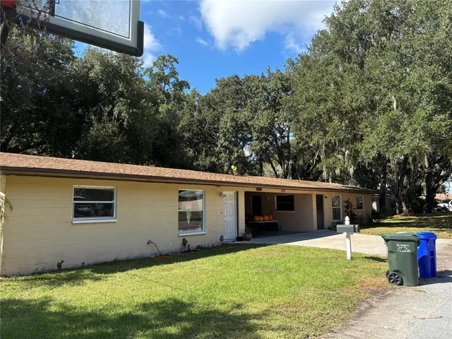 a view of a house with backyard and a tree