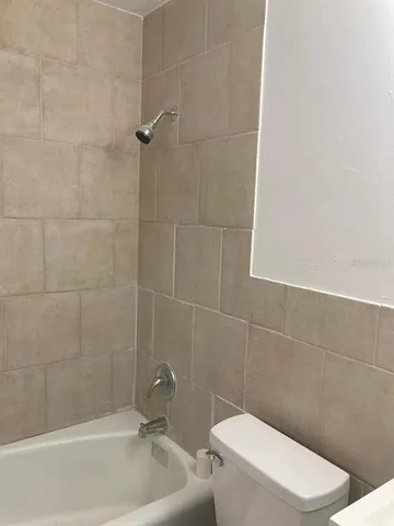 a white toilet sitting next to a bath tub