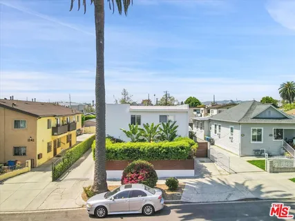 a front view of a house with a yard and potted plants
