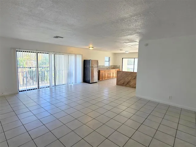 a view of a kitchen with furniture and a refrigerator