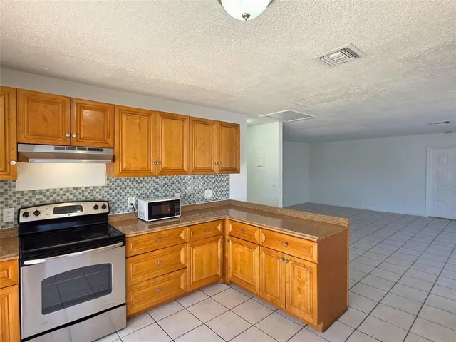 a kitchen with granite countertop cabinets stainless steel appliances and a counter space