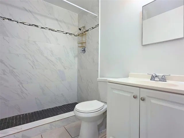 a bathroom with a toilet a sink and mirror