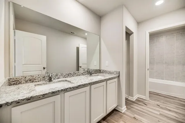 a bathroom with a granite countertop sink and a mirror