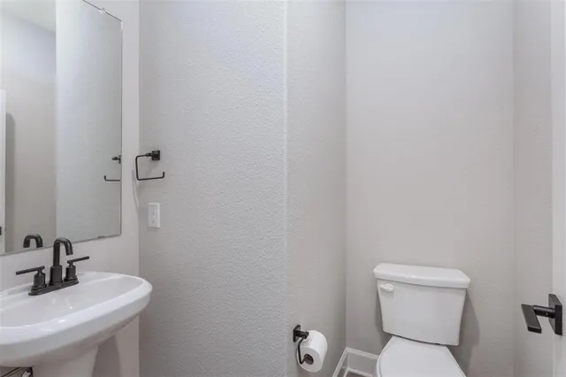 a bathroom with a toilet a sink and mirror