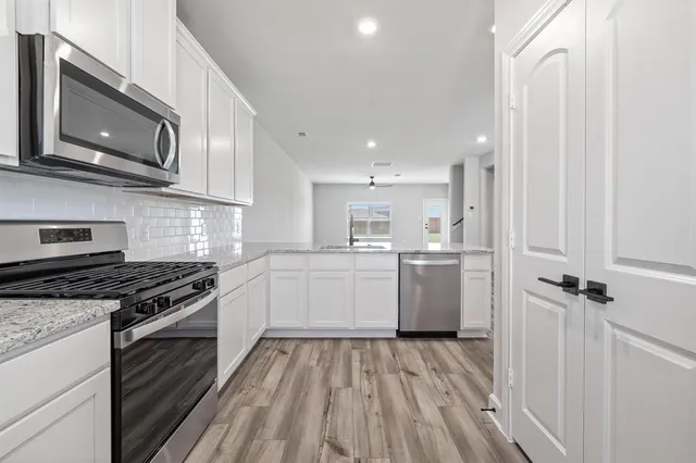 a kitchen with a stove a sink and a microwave