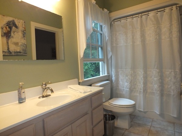 64 Wood Hill Road Monson, MA 01057 - Photo 12 of 30 a bathroom with a sink a toilet and shower curtain