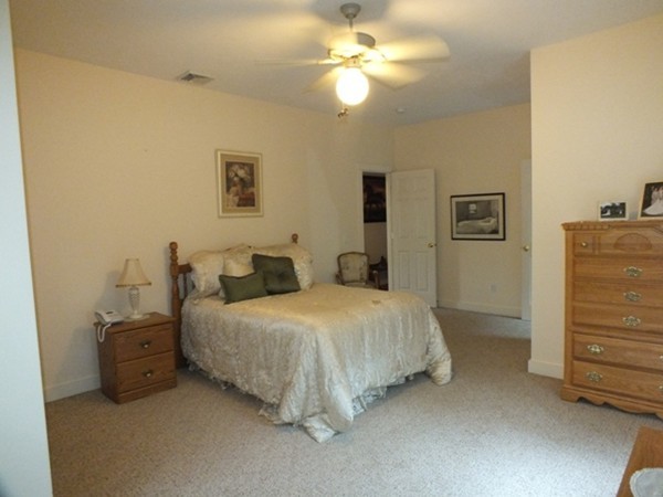 64 Wood Hill Road Monson, MA 01057 - Photo 14 of 30 a spacious bedroom with a bed and a chandelier