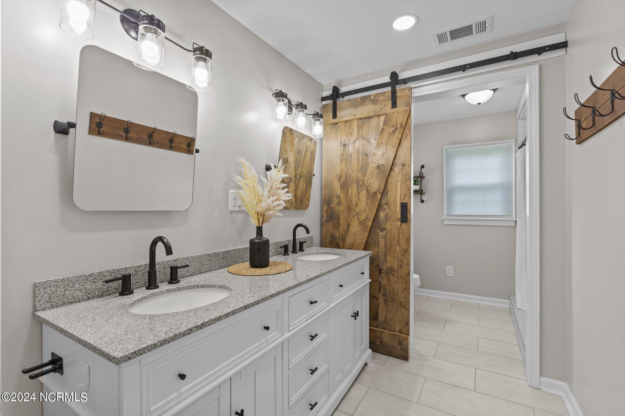 263 Core Creek Road Beaufort, NC 28516 - Photo 16 of 55 main house expanded bathroom double vanity, custom sliding barn door