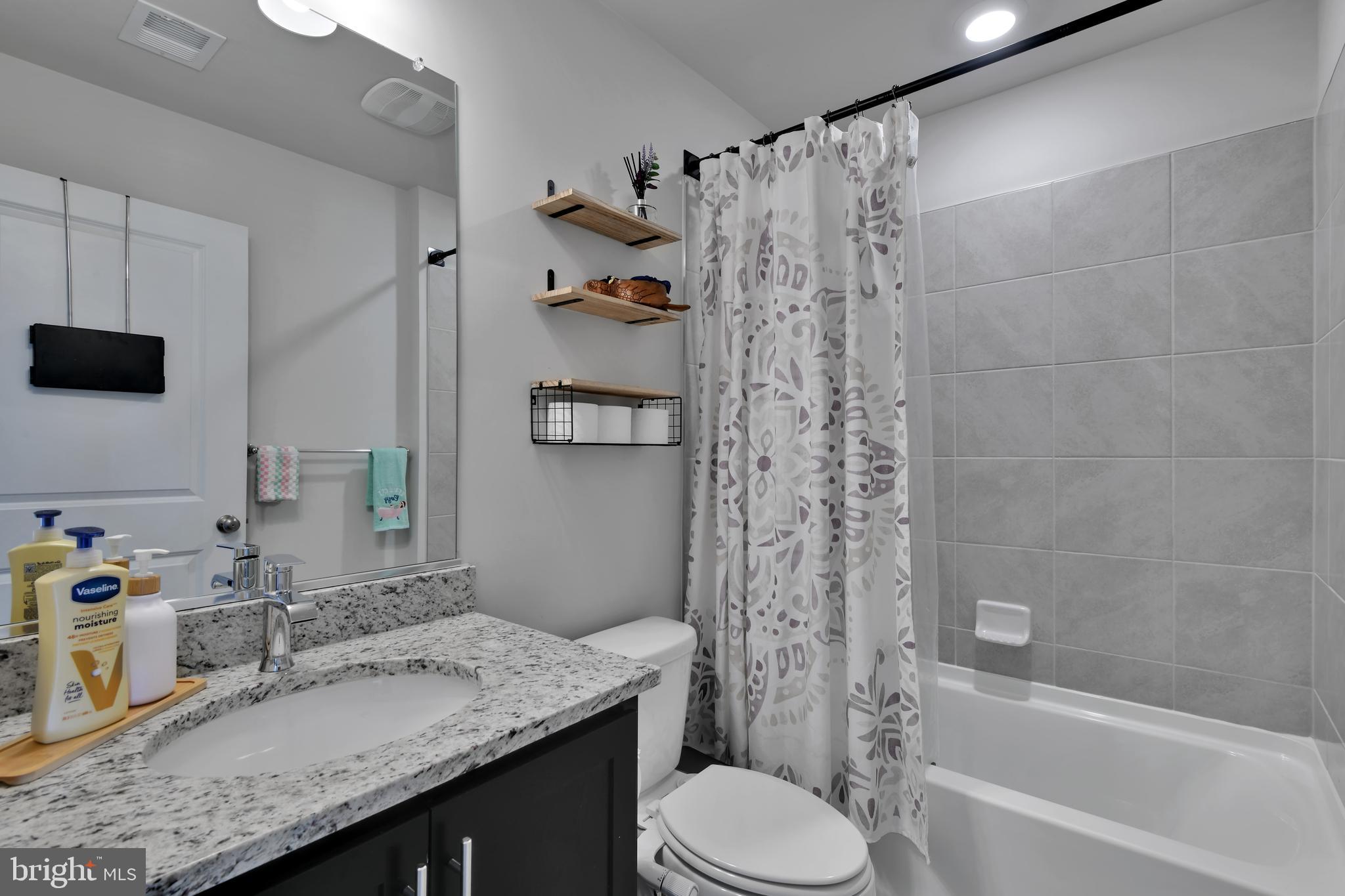 457 Tiller Street Frederick, MD 21701 - Photo 11 of 25 a bathroom with a granite countertop sink toilet and shower