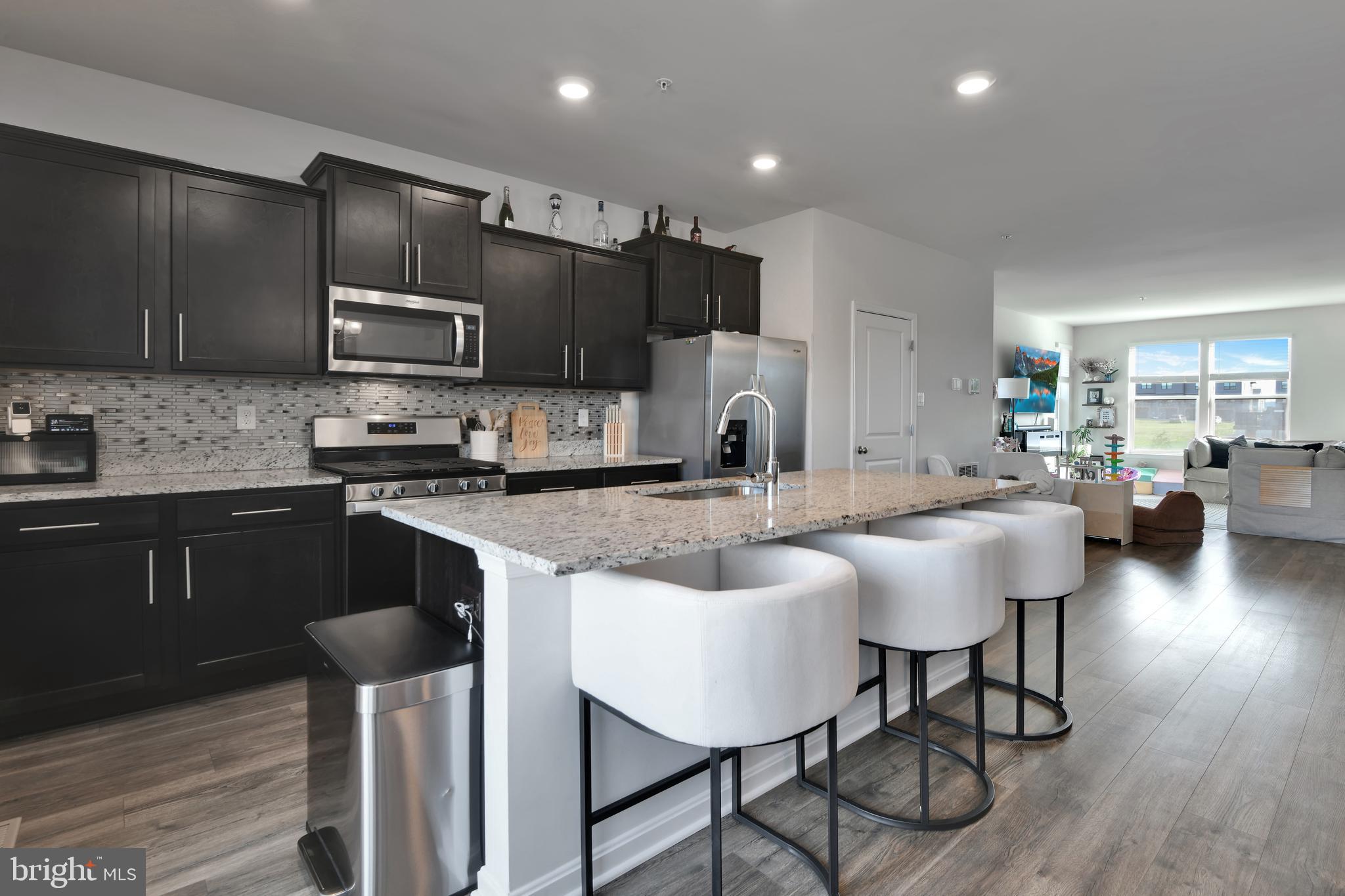 457 Tiller Street Frederick, MD 21701 - Photo 3 of 25 a kitchen with stainless steel appliances granite countertop a stove a sink a microwave a refrigerator and chairs