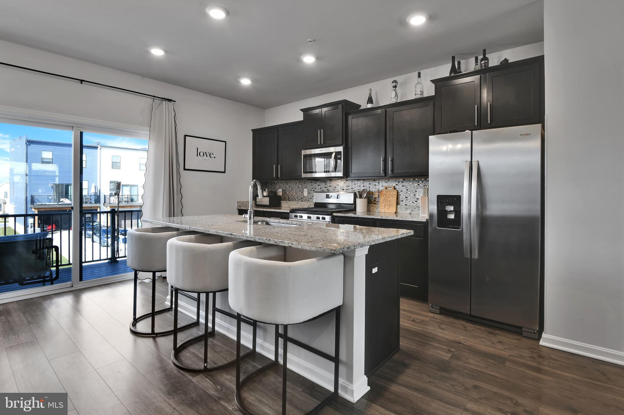 457 Tiller Street Frederick, MD 21701 - Photo 6 of 25 a kitchen with stainless steel appliances granite countertop a refrigerator a sink a stove a dining table and chairs