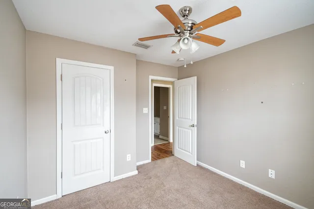 a bedroom with a bed and a chandelier fan